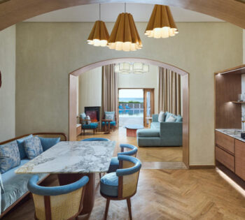 Presidiential uite dining table, seating area with sofa, view on the red sea and pool