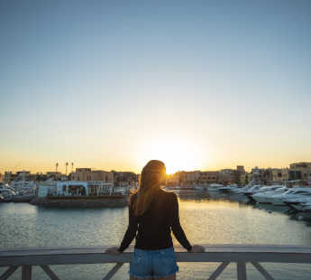 A female guest enjoying the Abu Tig Marina view sunset time from Turtle's Inn Hotel El Gouna Egypt Marina View Room Terrace