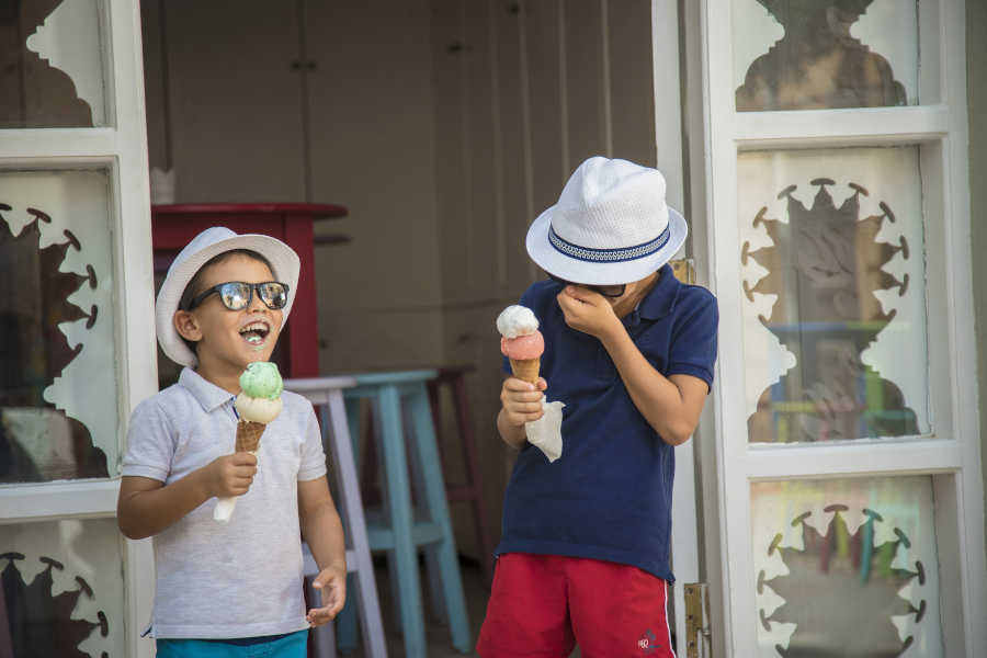 Two kids having fun and eating ice cream at Kids Club of Sheraton Miramar Resort in El Gouna