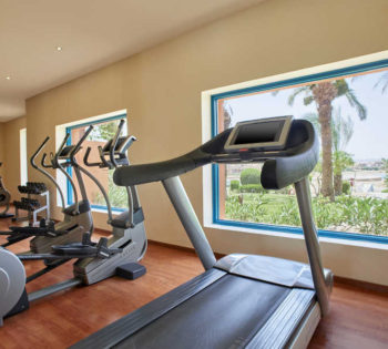 Treadmills and orbitracks with wide glass windows overlooking the lagoons at Fitness Center of Sheraton Miramar El Gouna