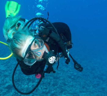 A girl is under the water of Red Sea with the diving equipments from Cinderella Diving Center at Sheraton Miramar El Gouna