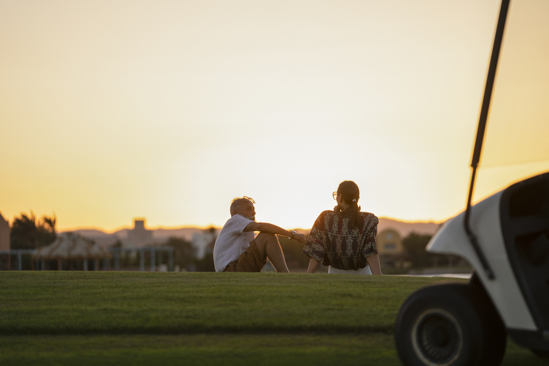 a man and a woman watching the sunset and chatting at the golf yard at steigenberger el gouna resort