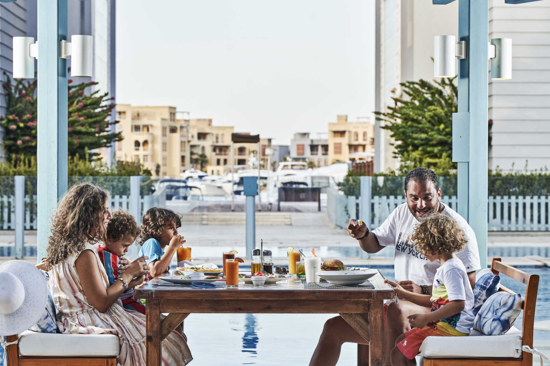 A family enjoying dining at Fanadir 4 Stars Hotel Kiki's Restaurant overlooking the New Marina El Gouna