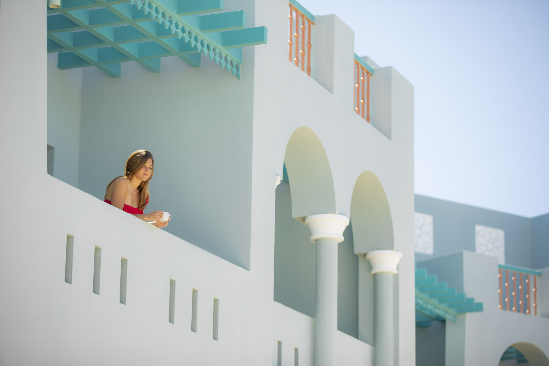guest looking from fanadir hotel el gouna room terrace while enjoying her coffee and Abu Tig Marina View