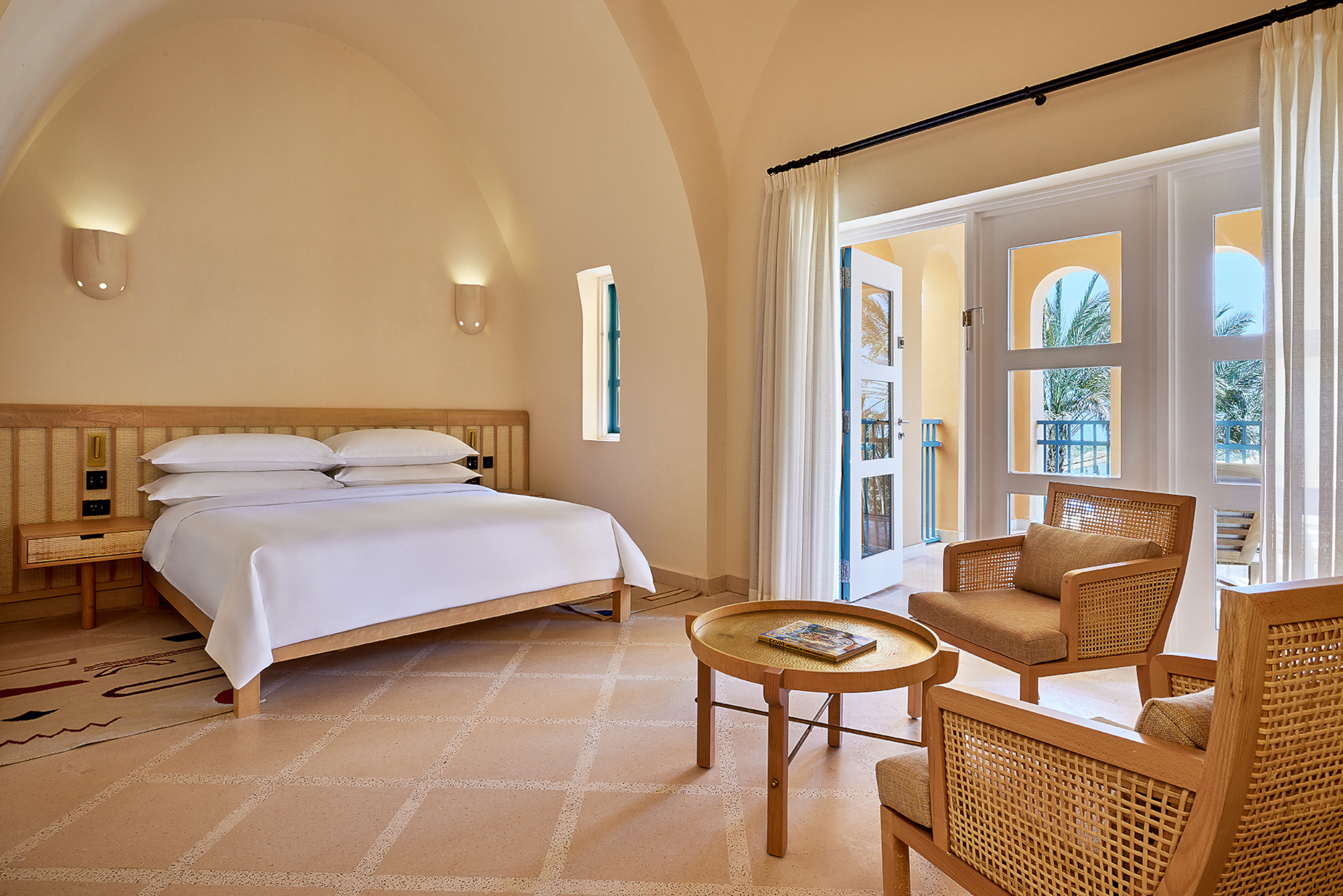 Luxury beddings and small coffee table in the deluxe beach front room at Sheraton Miramar El Gouna