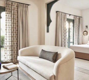 king bedroom & living area of Ali Pasha Hotel suite both modernly furnished with two patio doors with garden outside