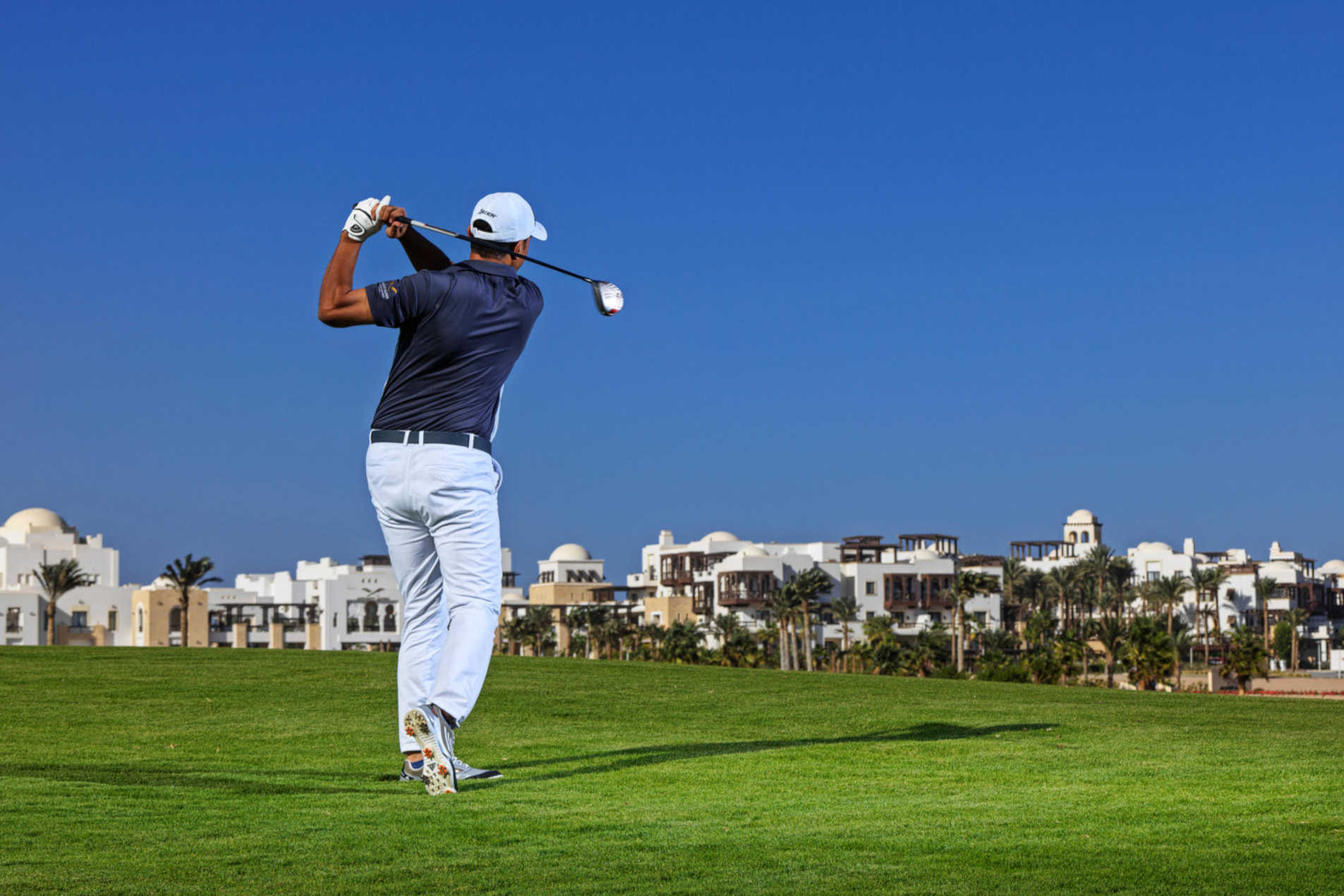 golfer playing with a view of ancient sands architect in front of him