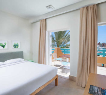 Captain's Inn Hotel El Gouna marina Suite furnished with king bed, flat screen TV ahead & has Abu Tig Marina terrace view