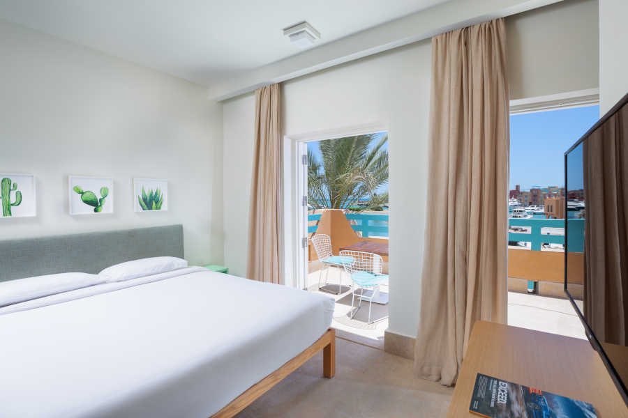 Captain's Inn Hotel El Gouna marina Suite furnished with king bed, flat screen TV ahead & has Abu Tig Marina terrace view