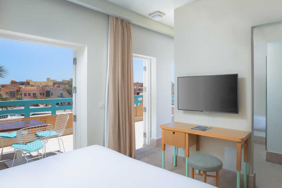Captain's Inn Hotel El Gouna marina Suite with Abu Tig Marina view terrace & furnished with king bed & flat screen TV ahead