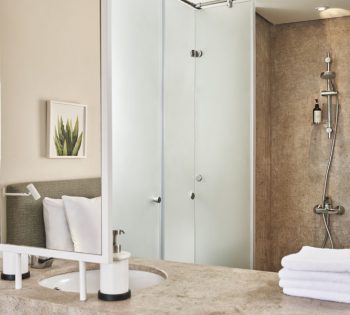 Captain's Inn El Gouna Hotel standard room shower, bathroom sink with mirror, bathroom accessories & white clean towels