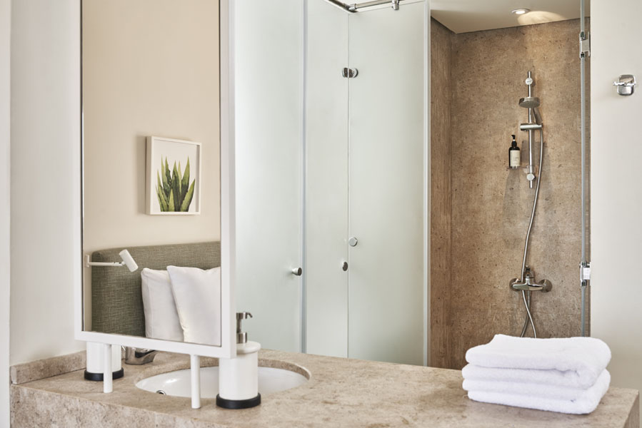 Captain's Inn El Gouna Hotel standard room shower, bathroom sink with mirror, bathroom accessories & white clean towels