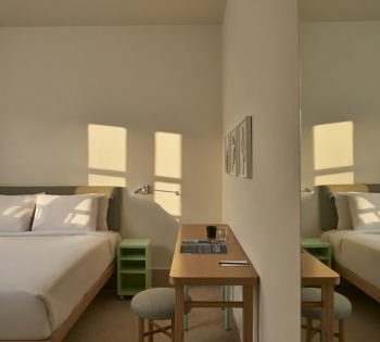 Captain's Inn Standard Room with king bed & a dressing table, wall desert plants paintings on beige walls and grey bed sheets