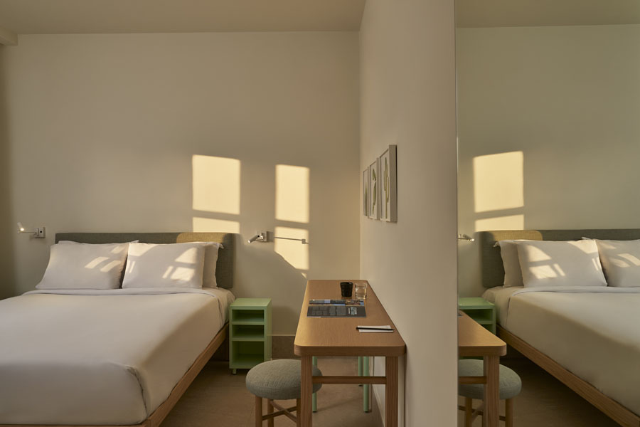 Captain's Inn Standard Room with king bed & a dressing table, wall desert plants paintings on beige walls and grey bed sheets