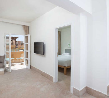 Captain's Inn Hotel El Gouna Captain Suite Modernly furnished with king bed, floor bed & a comfy sofa with flat screen TV ahead