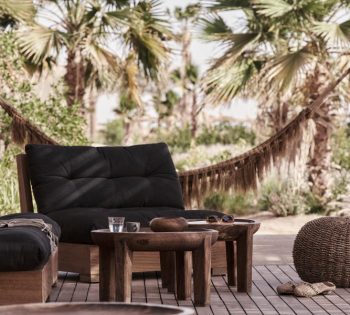 Beach club seating area with low chairs and hammac in casa cook hotel