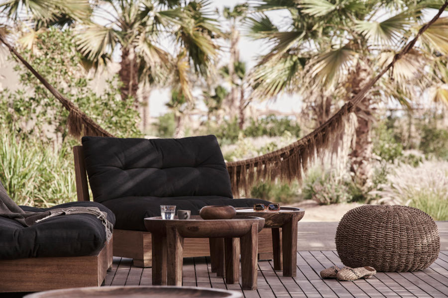 Beach club seating area with low chairs and hammac in casa cook hotel