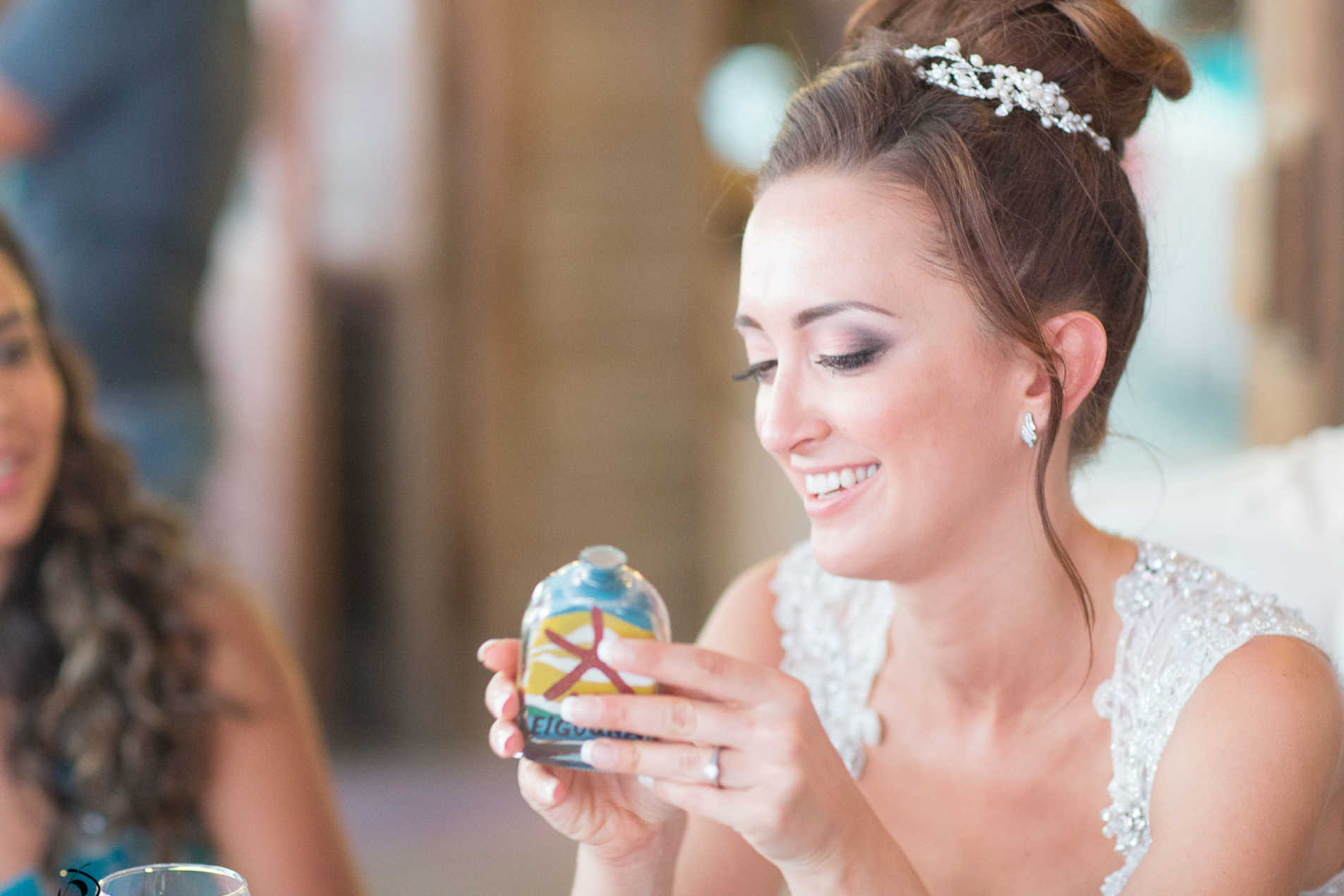 A bride in her wedding at Sultan Bey Hotel smiling and holding an art piece for El Gouna logo