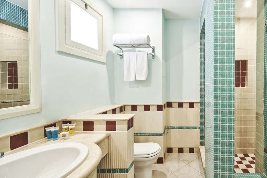 Turqouise beige marbeled bathroom of Junior Suite and tub with mirror and makeup mirror at Fanadir New Marina Hotel El Gouna