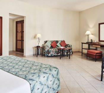 The spacious bedroom of Junior Suite at Fanadir New Marina Hotel with a sofa and table for coffee in El Gouna Egypt