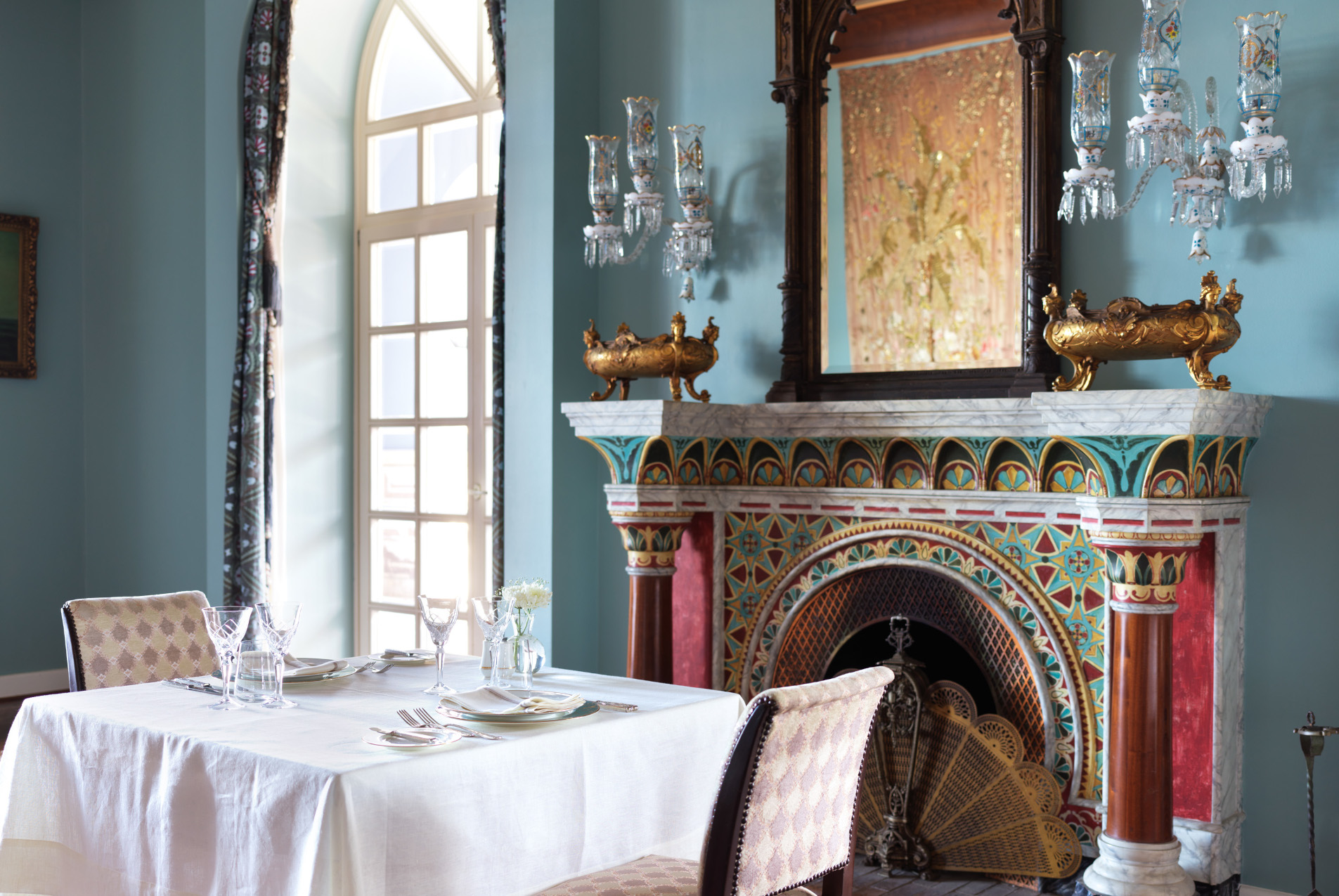 a dining table and a fireplace at la maison blueue el gouna