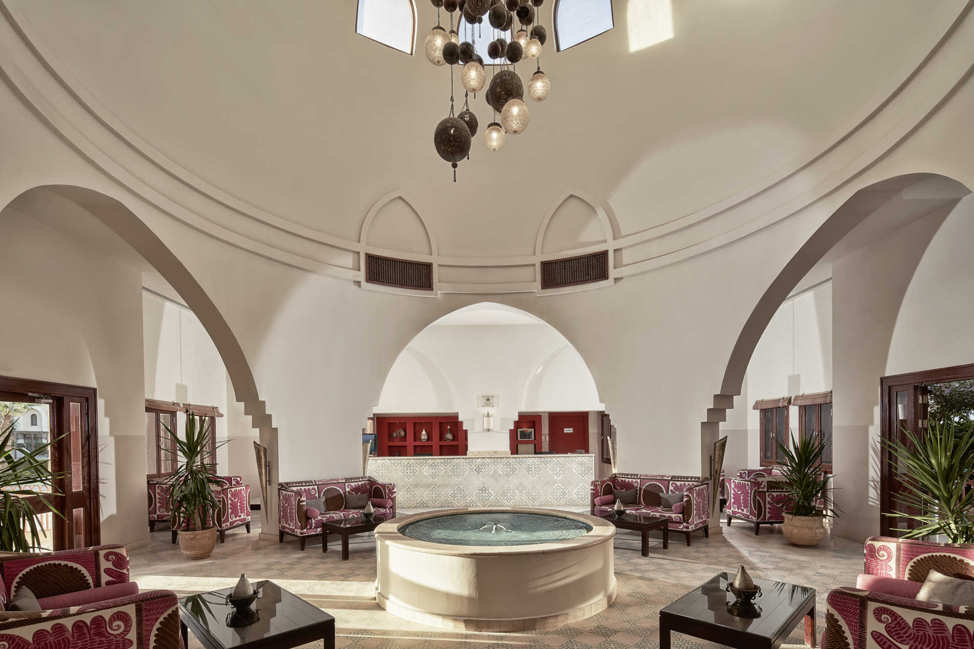 Mosaique Hotel Lobby in Moroccan style mixed with brown pink sofas, high ceiling and centered fountain in El Gouna