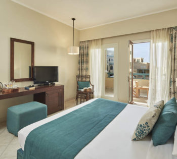 King bed sized room with a moroccan design and a window to a terrace overlooking the pool in Mosaique El Gouna 4 stars hotel