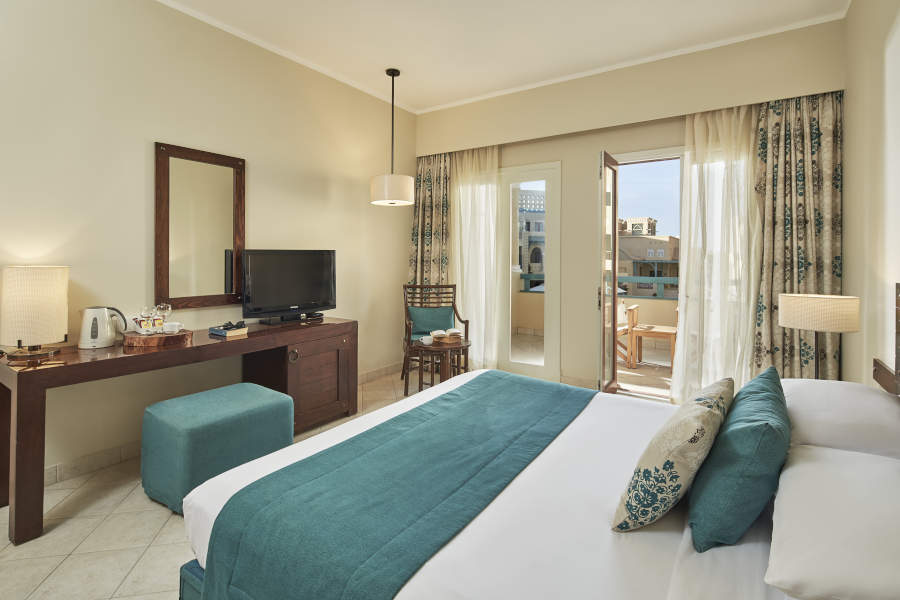 King bed sized room with a moroccan design and a window to a terrace overlooking the pool in Mosaique El Gouna 4 stars hotel