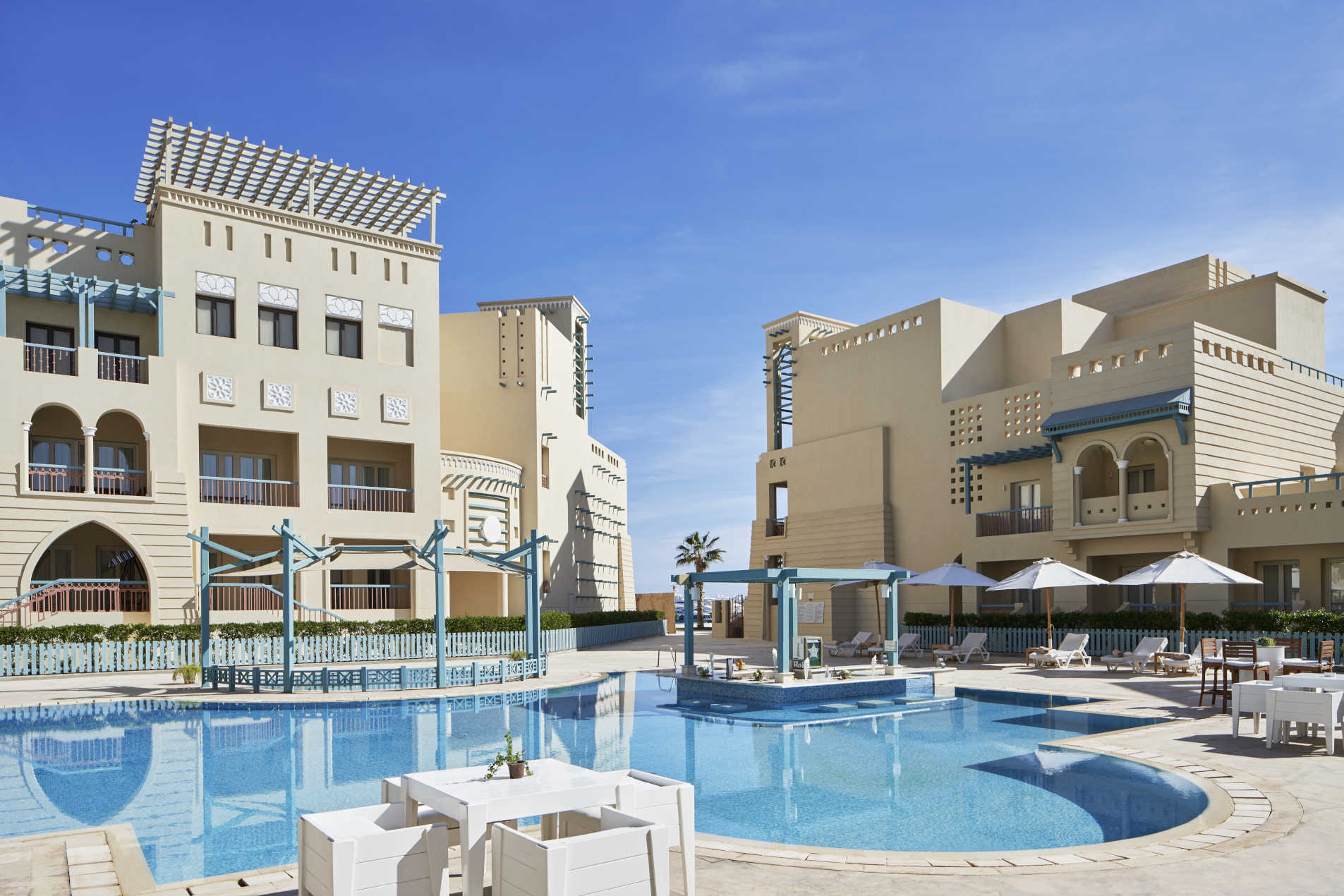 A daylight view for Mosaique adults pool with laidback sunbeds and a pool bar for chilling out in El Gouna 4 stars hotel