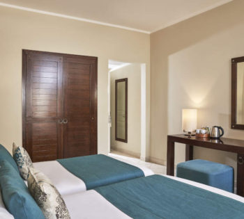 The twin luxury beddings of Mosaique Hotel with dressing table and coffee amenities and a wardrobe in El Gouna Red Sea