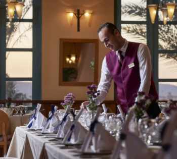 A waiter setting up a table in the La Rotisserie Restaurant in the Steigenberger Resort El Gouna Golf Tower