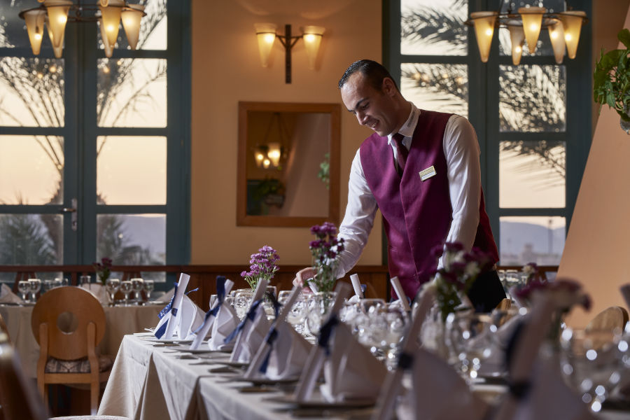 A waiter setting up a table in the La Rotisserie Restaurant in the Steigenberger Resort El Gouna Golf Tower