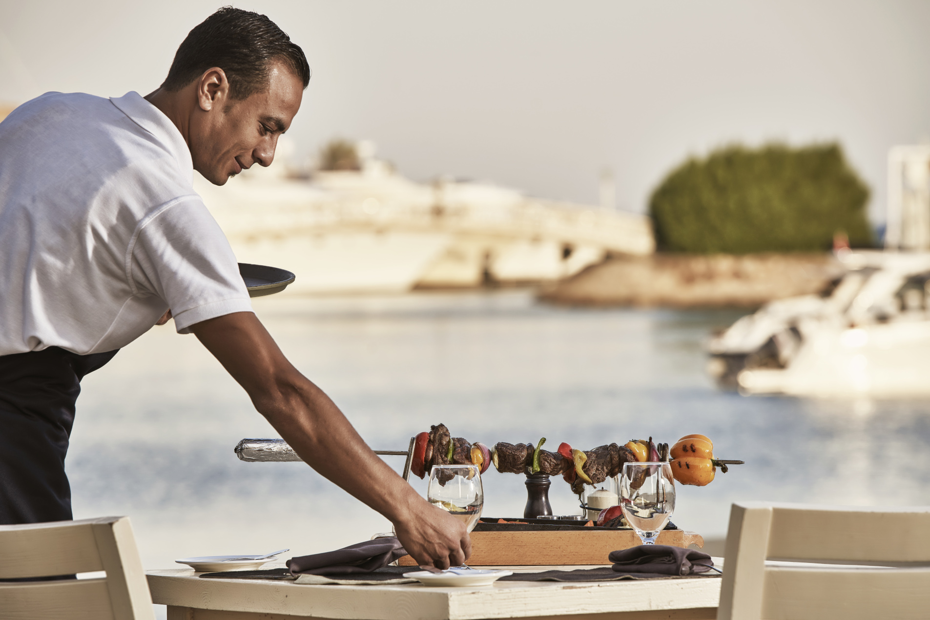 a waiter serving a kebab at steak house in elgouna