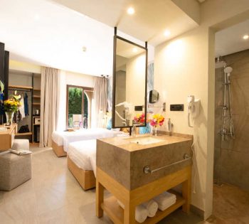 Overview of comfort room with bathroom and twin beds at Rihana Resort