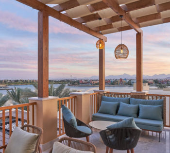 bar on terrace with pink sunset sky overlooking lagoons in el gouna resort