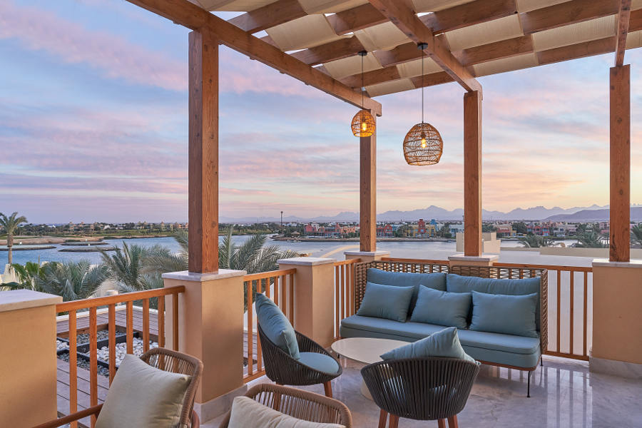 bar on terrace with pink sunset sky overlooking lagoons in el gouna resort