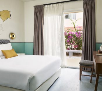 Earth Theme standard room on courtyard of Turtl'es Inn hotel El Gouna, with king size bed & cow hand-drawn art behind