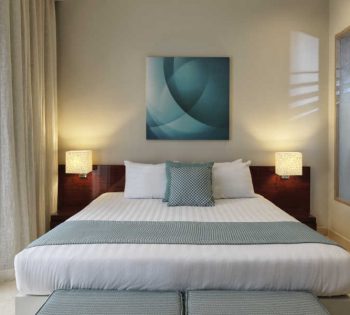 The king bedroom of Ancient Sands Apartment in El Gouna decorated with beige-blue theme and a glass window for a daylight