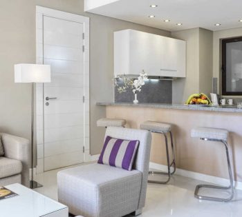 The living area of junior suite furnished with sofas and the bar of the kitchen in Ancient Sands Golf Resort and Residences in El Gouna