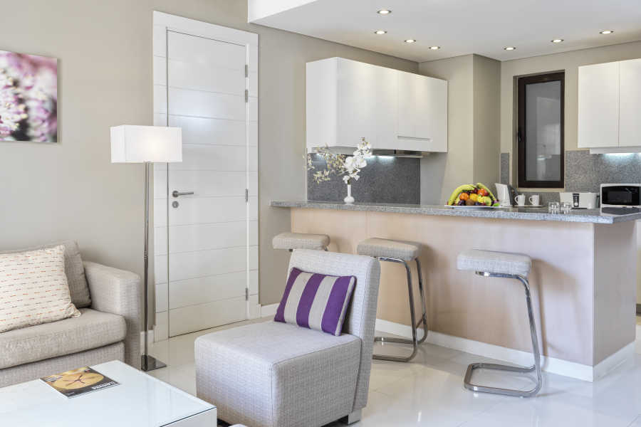 The living area of junior suite furnished with sofas and the bar of the kitchen in Ancient Sands Golf Resort and Residences in El Gouna