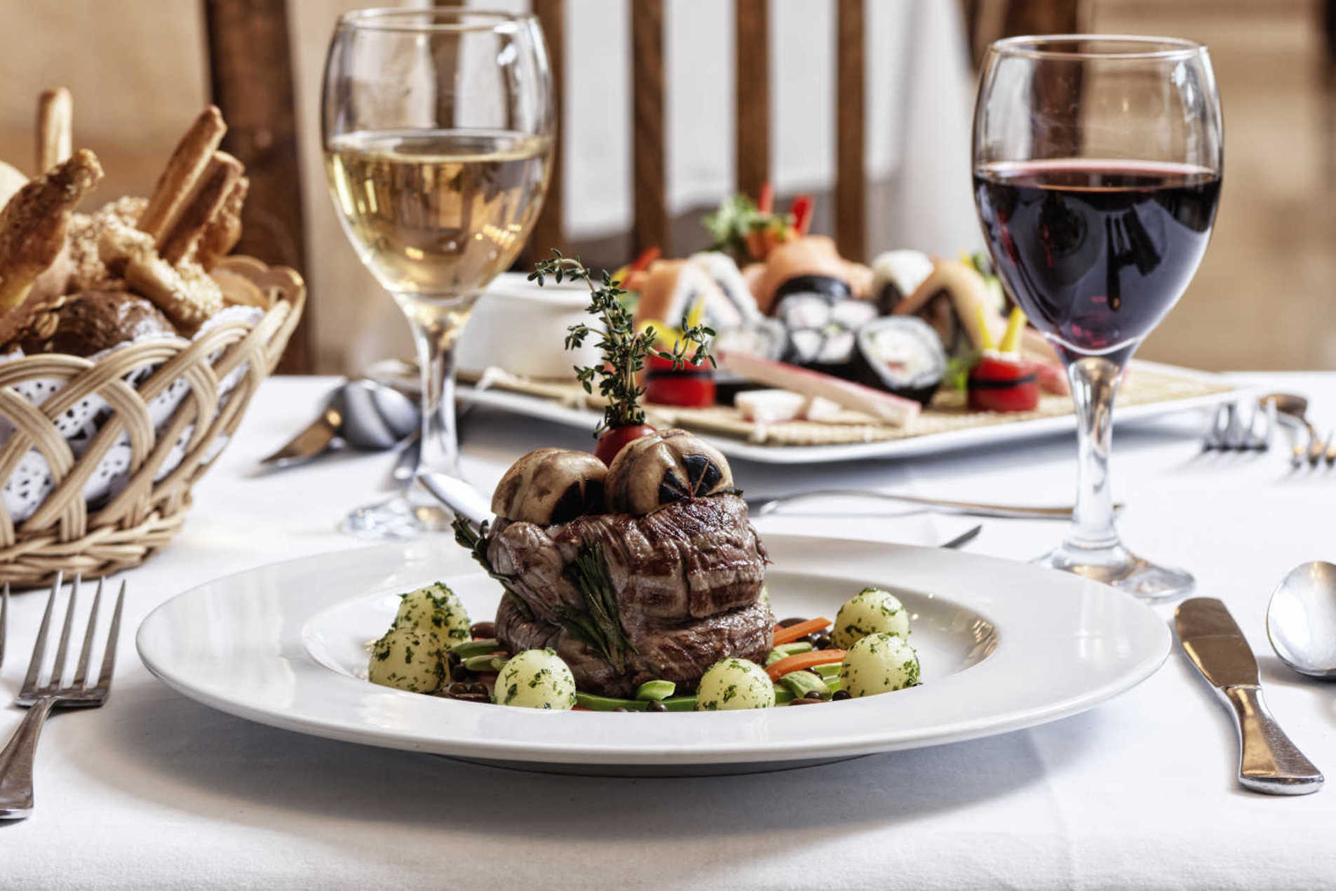 The dining at Ancient Sands and a steak plate served with drinks and bakeries basket in El Gouna resort restaurant