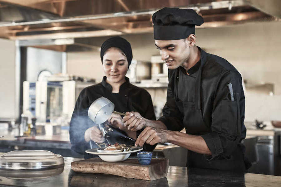 Two chefs are cooking live at The Kitchen Club of Casa Cook El Gouna Hotel