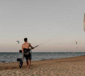 A man is kitesurfing in Casa Cook El Gouna sandy beach at Duotone the kite boarding center