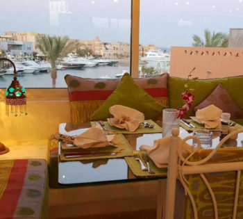 Indoors of Chez Chantal restaurant in the second floor of Turtle's Inn Hotel, With a day time window view on abu tig marina