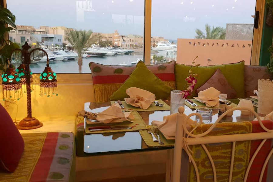 Indoors of Chez Chantal restaurant in the second floor of Turtle's Inn Hotel, With a day time window view on abu tig marina