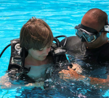 A diver with a kid from Orca Diving Center at the pool of Labranda Club Paradisio Hotel in El Gouna for a diving lesson