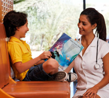 A doctor is playing with a kid at El Gouna Hospital reception