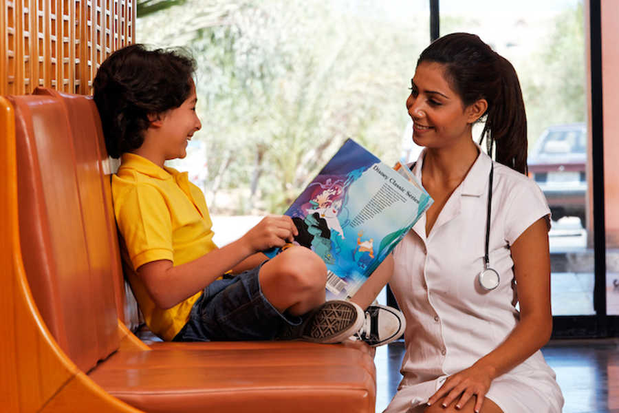 A doctor is playing with a kid at El Gouna Hospital reception