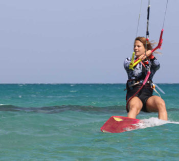 A girl is kitesurfing in the wind and the blue waters of Red Sea in El Gouna Egypt