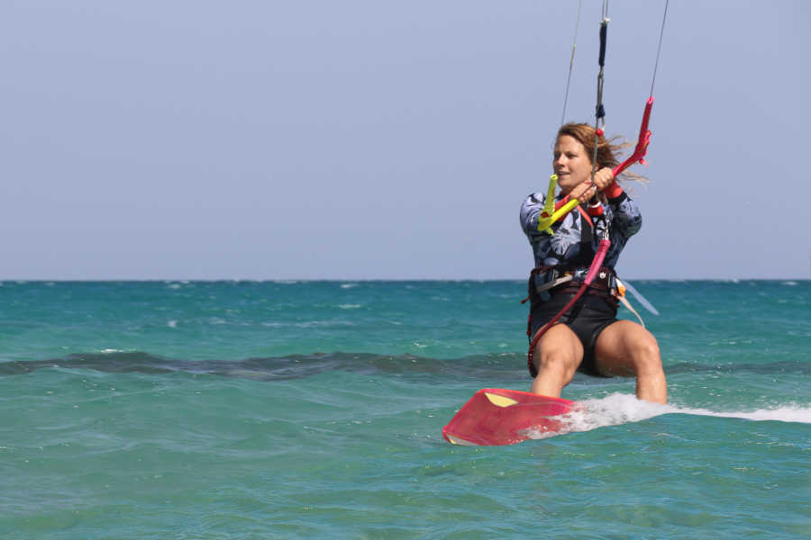 A girl is kitesurfing in the wind and the blue waters of Red Sea in El Gouna Egypt
